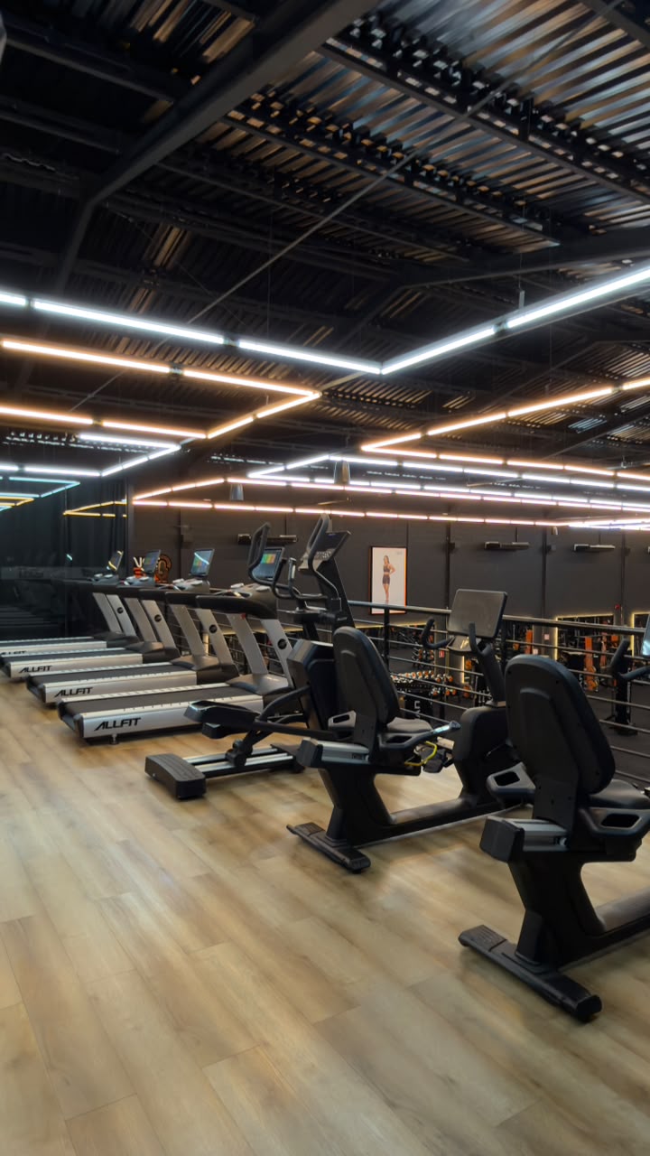 Esteiras ALLFIT em fila no mezanino com vista para o salão de musculação