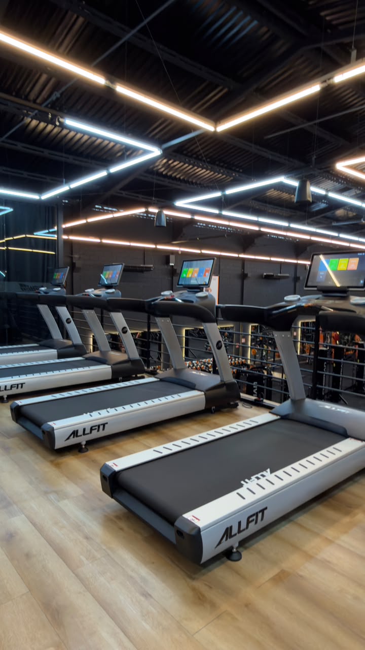 Mezanino do cardio com esteiras ALLFIT, elípticos e sinalização CARDIO na parede